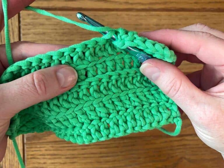 Hands holding a crochet sample demonstrating crocheting in the FLO